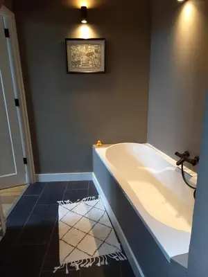 a bath tub in a bathroom with a picture on the wall at Vakantiehuis De Oude Bakkerij in Katwijk aan Zee