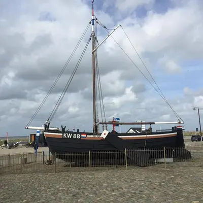 a boat sitting on the sand on the beach at Vakantiehuis De Oude Bakkerij in Katwijk aan Zee