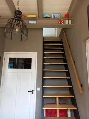 a staircase in a room with a white door at Vakantiehuis De Oude Bakkerij in Katwijk aan Zee