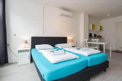 a bedroom with two beds with blue and white pillows at RedLight District Private Smokers Friendly Studio in Amsterdam