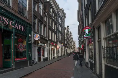 a city street with people walking down the street at RedLight District Private Smokers Friendly Studio in Amsterdam