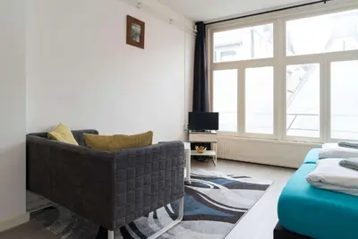 a living room with a couch and a window at RedLight District Private Smokers Friendly Studio in Amsterdam