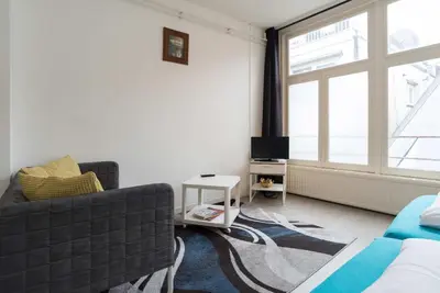 a living room with a couch and a window at RedLight District Private Smokers Friendly Studio in Amsterdam