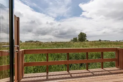 a view of a field from the deck of a house at Dutchen Erfgoedpark De Hoop Appartementen in Uitgeest
