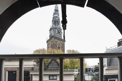 a clock tower in the distance from a window at RedLight District Smokers Friendly Private Studio in Amsterdam