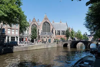 a boat in a river in front of a church at RedLight District Smokers Friendly Private Studio in Amsterdam
