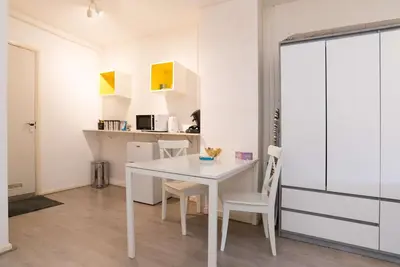 a white dining room with a white table and chairs at RedLight District Smokers Friendly Private Studio in Amsterdam
