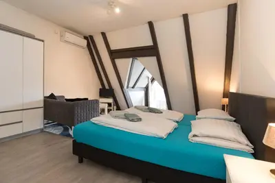 a bedroom with a blue bed with a large window at RedLight District Smokers Friendly Private Studio in Amsterdam