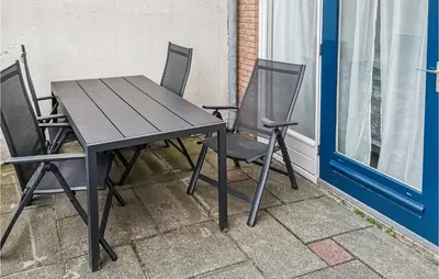 a black table and two chairs on a patio at Zeekalfje in Bergen aan Zee