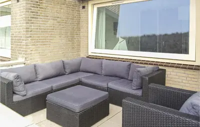 a couch sitting on a patio next to a window at Stern in Bergen aan Zee