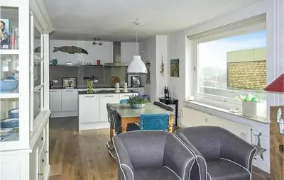 a kitchen with a table and chairs and a window at Stern in Bergen aan Zee