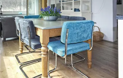 a table with three chairs and a table with a plant on it at Stern in Bergen aan Zee