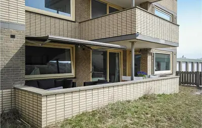 a brick house with a porch with chairs at Stern in Bergen aan Zee