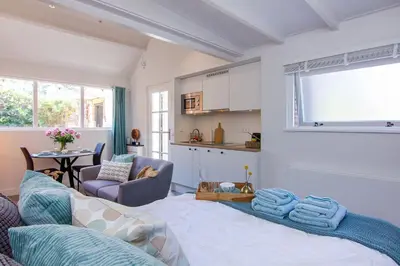 a living room with a bed and a kitchen at Coast Guesthouse in Zandvoort