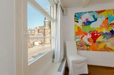 a room with a window and a painting on the wall at B&B The Catch Apartment in Amsterdam