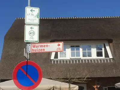 a street sign in front of a building at Herberg het Landhuis in Schoorl