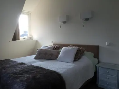a bedroom with a bed with two pillows and a window at Herberg het Landhuis in Schoorl