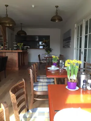 a dining room with tables and chairs with flowers on them at Herberg het Landhuis in Schoorl