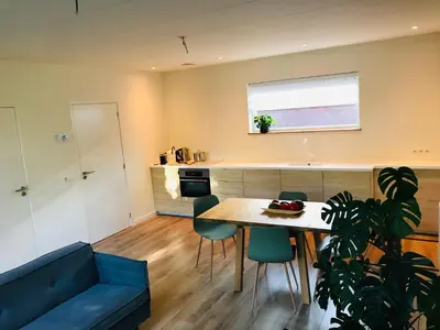 a living room with a table and a blue couch at Guest House Amersfoort Center in Amersfoort
