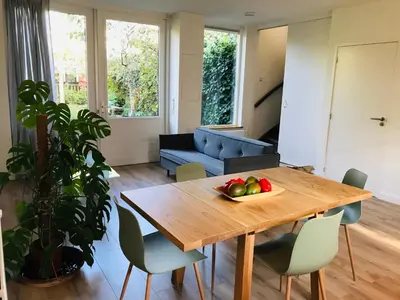 a living room with a wooden table with a bowl of fruit on it at Guest House Amersfoort Center in Amersfoort