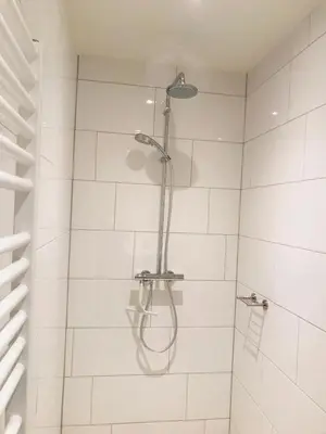 a shower with a shower head in a bathroom at Guest House Amersfoort Center in Amersfoort