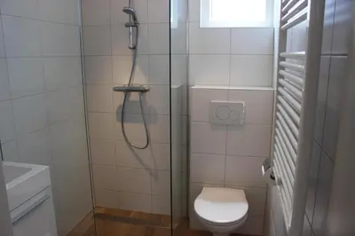 a bathroom with a shower with a toilet and a sink at Heerlijke vakantiehuisjes in Egmond in Egmond aan Zee