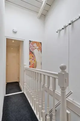 a staircase in a white room with a painting on the wall at Adam's loft in Amsterdam