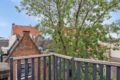 a house with a wooden fence and a tree at Adam's loft in Amsterdam