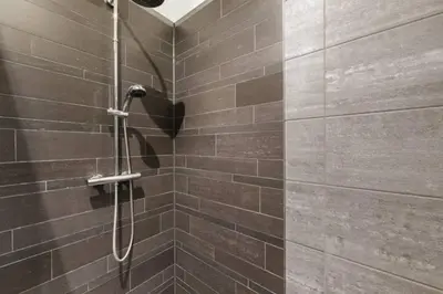 a shower stall in a bathroom with brown tiles at Adam's loft in Amsterdam