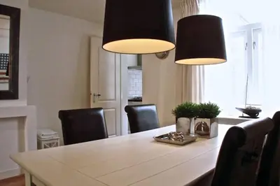 a dining room table with chairs and two lights at Stylish Canalhouse B in Amsterdam