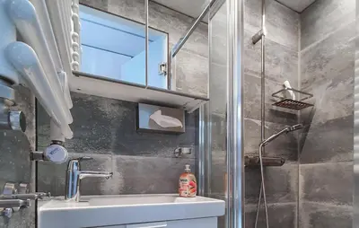 a bathroom with a sink and a shower with a mirror at Mermaid-Hausboote 2 in Lelystad