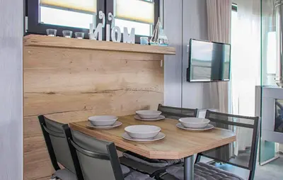 a dining room with a wooden table and chairs at Mermaid-Hausboote 2 in Lelystad
