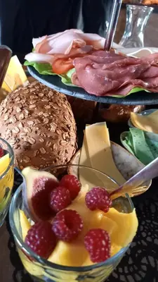 two plates of food with fruit in a bowl at De Oude Smederij voor 2 personen in 't Veld in De Leijen