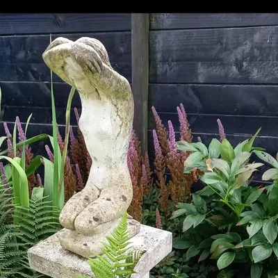a statue of a woman in a garden at De Oude Smederij voor 2 personen in 't Veld in De Leijen