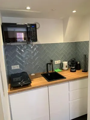 a kitchen with a counter with a microwave and a sink at The Harbour Leiden in Leiden