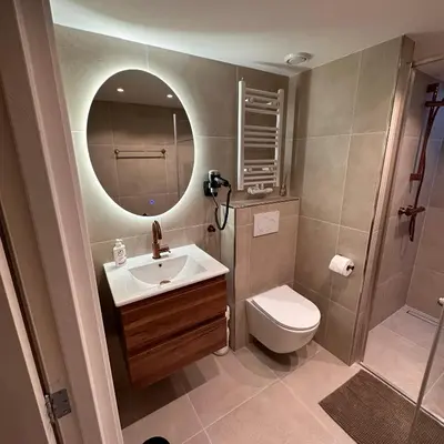a bathroom with a sink and a toilet and a mirror at The Harbour Leiden in Leiden