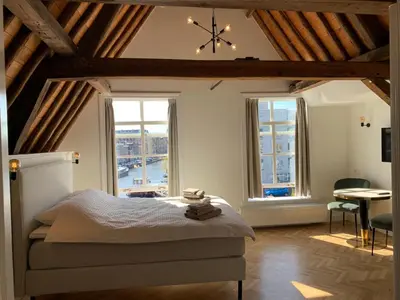 a bedroom with a bed and a large window at The Harbour Leiden in Leiden