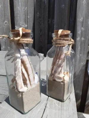 two glass jars filled with shells on a wooden table at Sunny Residence in Zandvoort