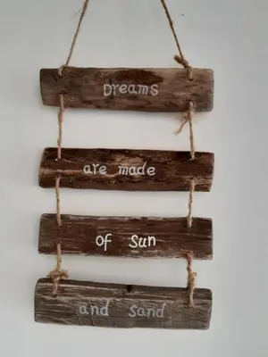 an art made of wood with the words dreams are made of sun and sand at Sunny Residence in Zandvoort
