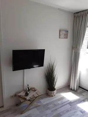 a living room with a flat screen tv on a wall at Sunny Residence in Zandvoort