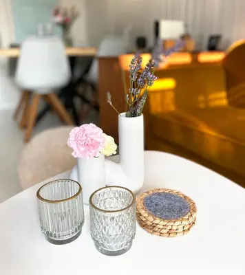 a table with three silver vases and flowers on it at Beach House For You - Luxe verblijf, 5 min van het strand in Katwijk aan Zee