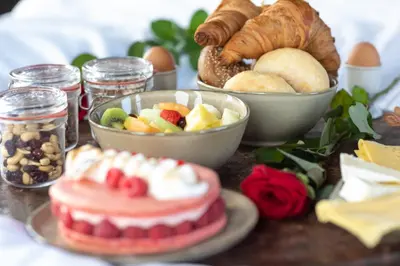 a table topped with bowls of fruit and pastries and bread at The Clock Tower in Weesp