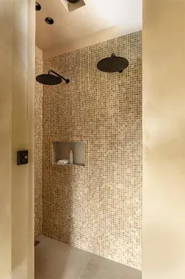 a bathroom with a shower with brown tiles at The Clock Tower in Weesp