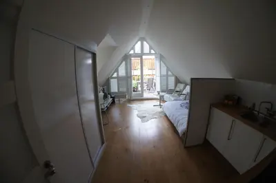 a attic room with a bed and a sink at Prince On The Roof in Amsterdam