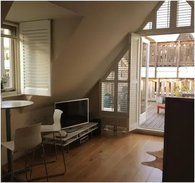a living room with a television and a table and chairs at Prince On The Roof in Amsterdam