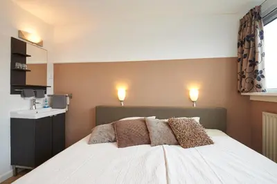 a bedroom with a white bed with two pillows on it at B&B HutSpot in Amsterdam