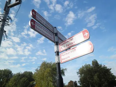 a street sign with several signs on a pole at B&B HutSpot in Amsterdam