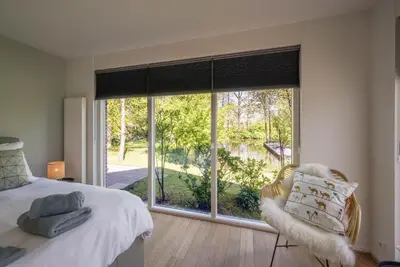 a bedroom with a bed and a large window at 't Kleine eiland in Zuid-Scharwoude