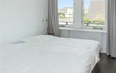 a white bed in a room with a window at Awesome Apartment In Bergen An Zee in Bergen aan Zee