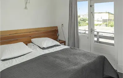 a bedroom with a bed and a window with a view at Awesome Apartment In Bergen An Zee in Bergen aan Zee